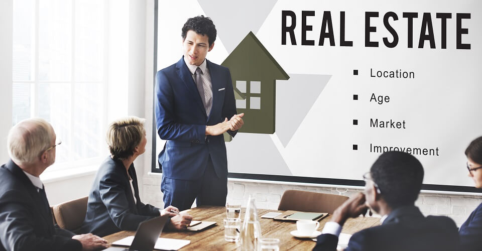 A man shows a presentation to people about real estate